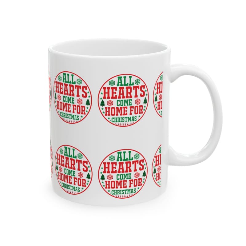 White ceramic mug decorated with repeating red and green circular Christmas-themed designs that say ’All Hearts Come Home For Christmas’