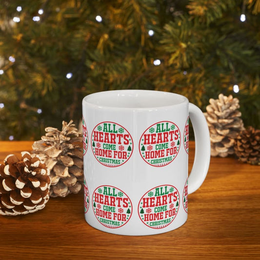 White ceramic mug with repeating circular ’All Hearts Come Home For Christmas’ designs in red and green.