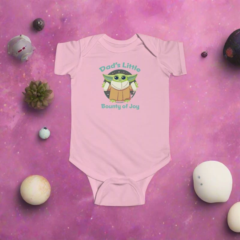 Pink baby onesie featuring a cartoon ’Baby Yoda’ character with text ’Dad’s Little Bounty of Joy’.