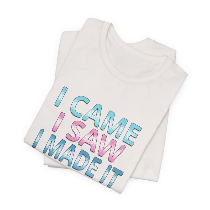 White t-shirt with blue and pink text reading ’I CAME I SAW I MADE IT’