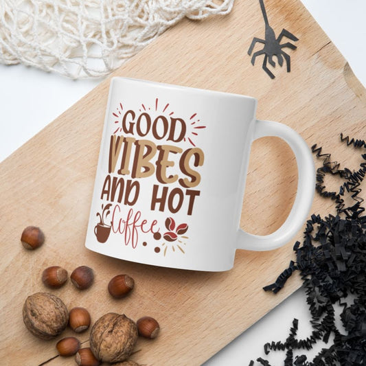 White mug with ’Good Vibes and Hot Coffee’ text in brown and red lettering.