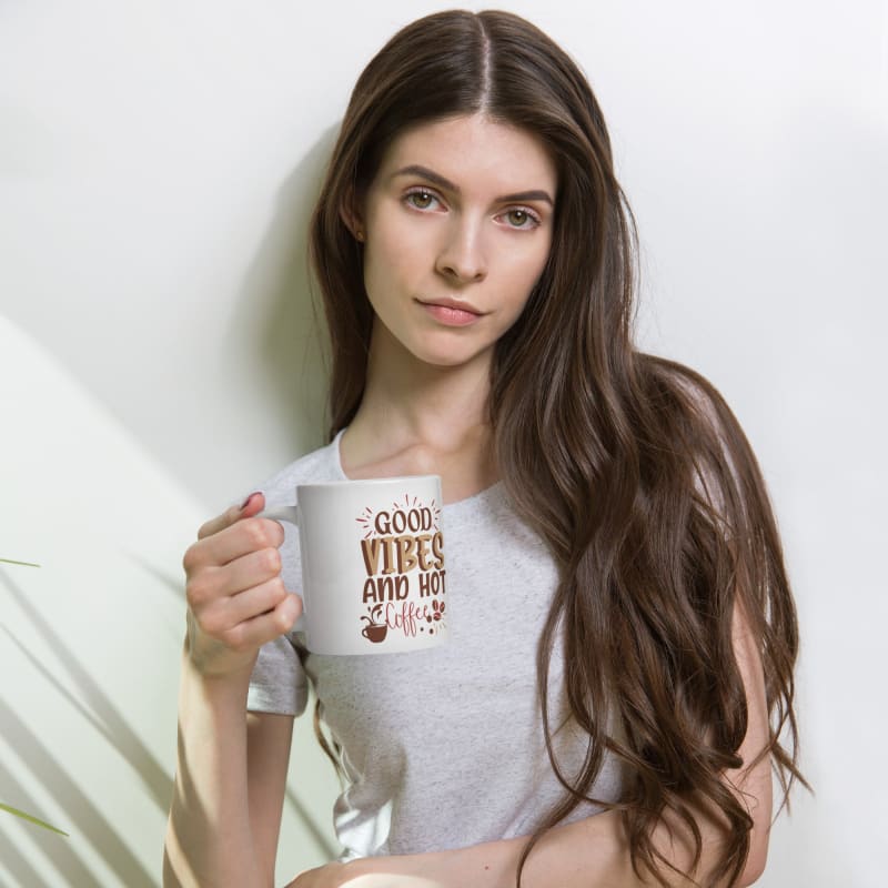 Woman with long dark hair holding a coffee mug.