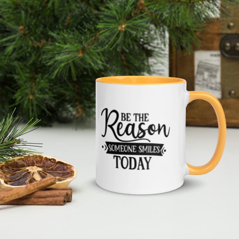 White mug with yellow interior featuring the inspirational text ’Be the Reason Someone Smiles Today’.