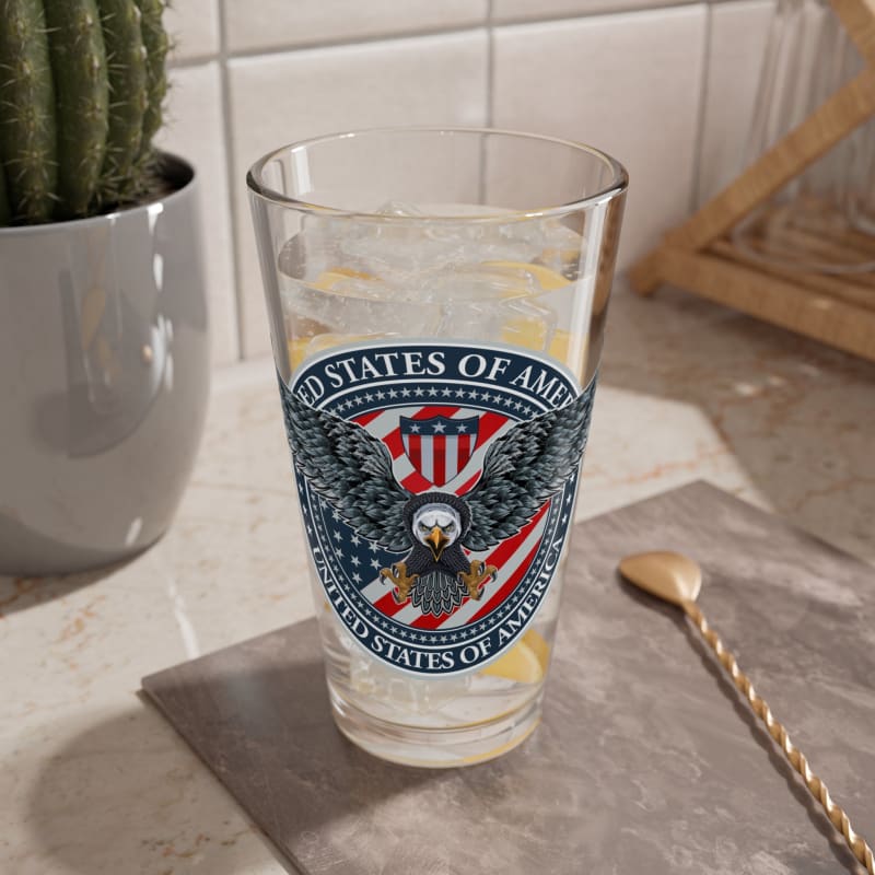 Glass with the United States of America seal printed on it, containing a beverage with ice.