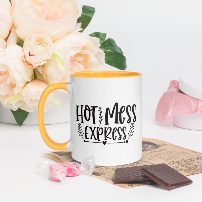 White mug with yellow rim and handle featuring the text ’HOT MESS EXPRESS’ in black lettering.