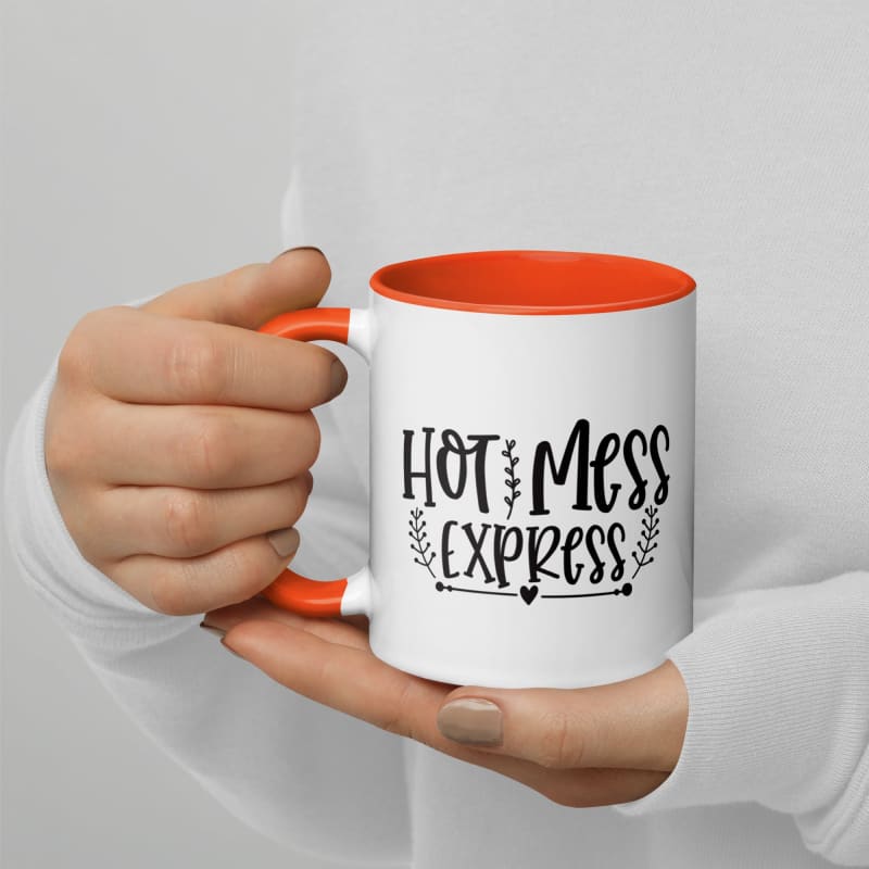 White ceramic mug with orange interior and handle, featuring the text ’Hot Mess Express’ in black lettering.