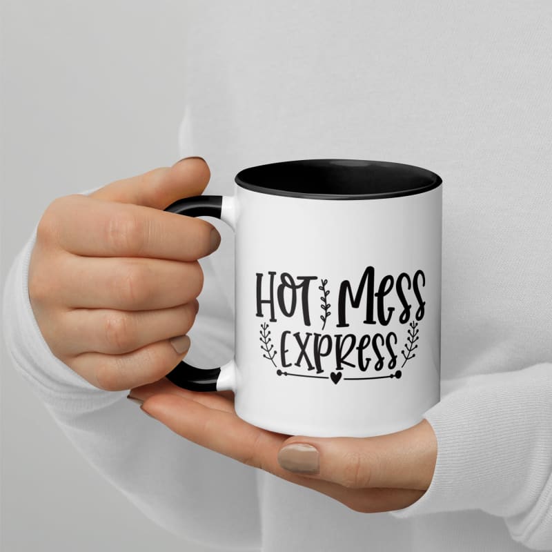 White coffee mug with ’Hot Mess Express’ printed on it, held by hands.