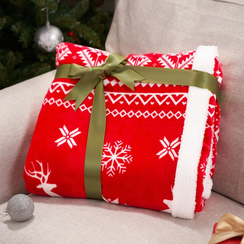 Red and white snowflake-patterned blanket tied with a green bow.