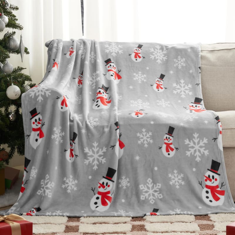 A grey fleece blanket with snowmen and snowflake patterns.