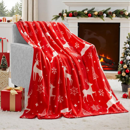 Red fleece blanket with white reindeer and snowflake pattern.