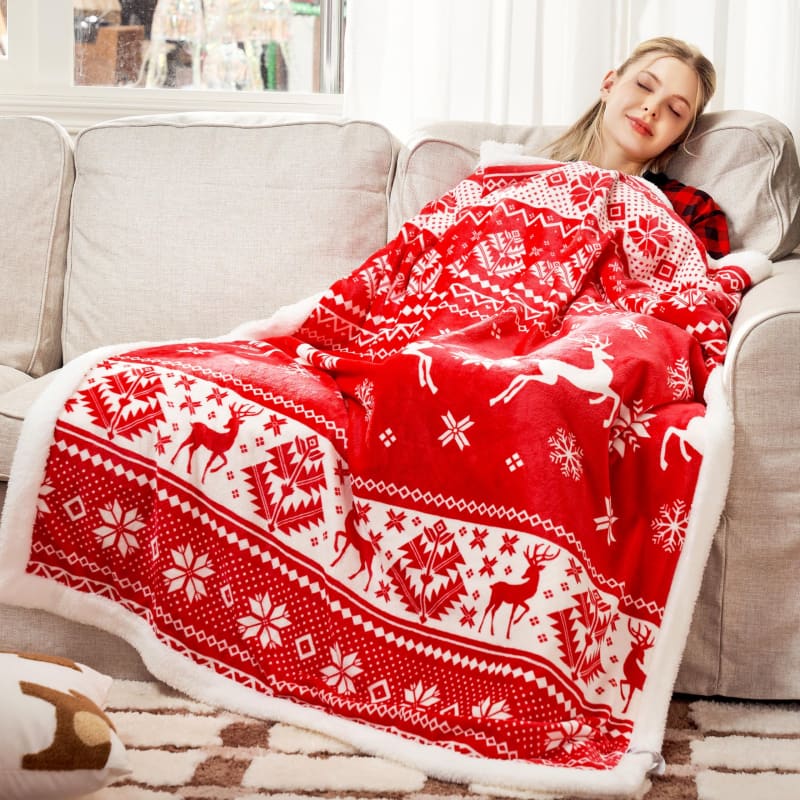 Red and white Nordic-patterned throw blanket with reindeer and snowflake designs.