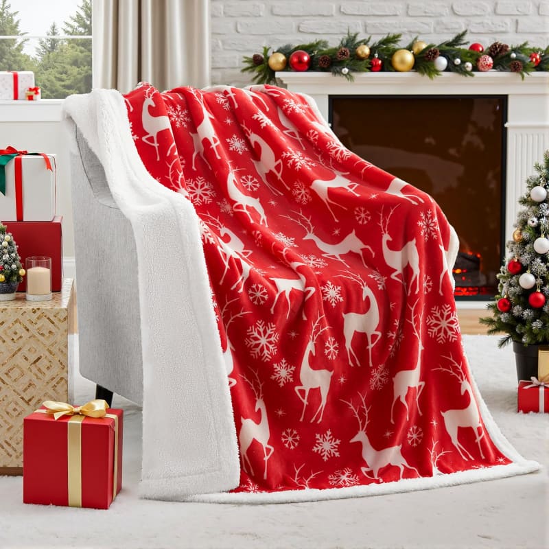 Red and white fleece blanket with reindeer and snowflake pattern.