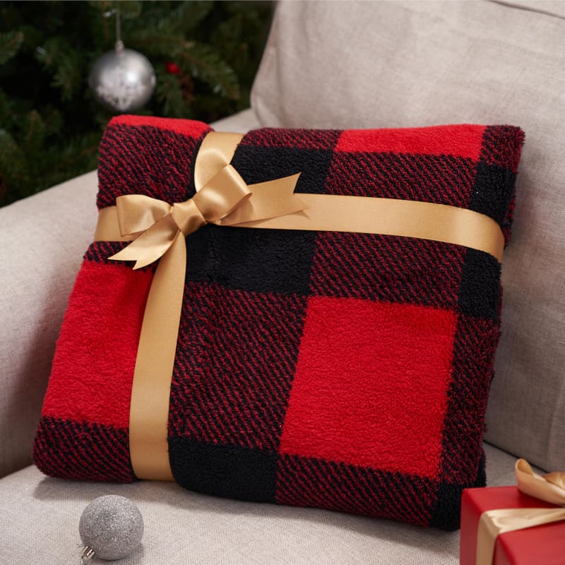 Red and black buffalo plaid blanket tied with a gold ribbon bow.