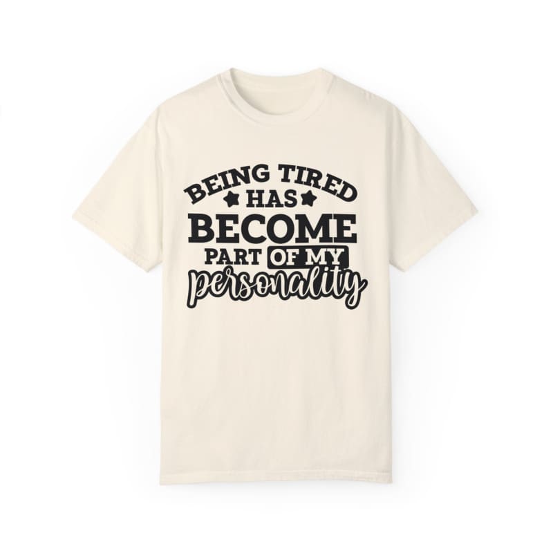 Cream-colored t-shirt with black text saying ’Being tired has become part of my personality’.