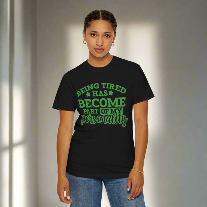 Black t-shirt with green text reading ’BEING TIRED HAS BECOME PART OF MY PERSONALITY’.