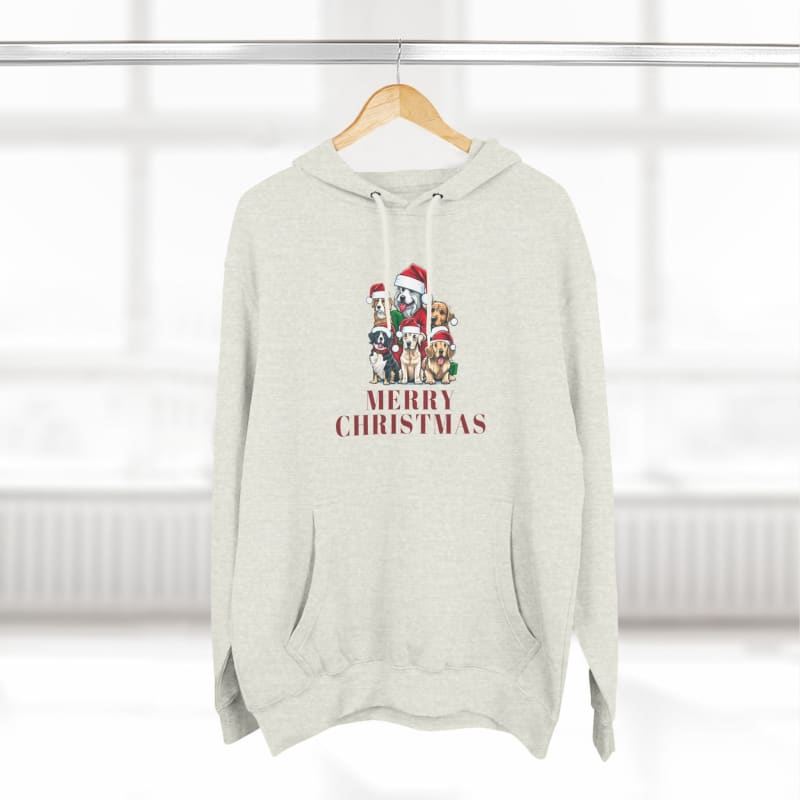 Light-colored hoodie sweatshirt featuring cartoon dogs wearing Santa hats and ’Merry Christmas’ text.