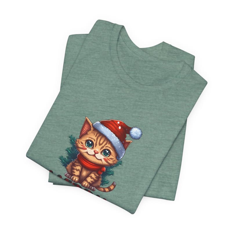 Folded sage green t-shirt featuring a cartoon orange tabby kitten wearing a Santa hat.