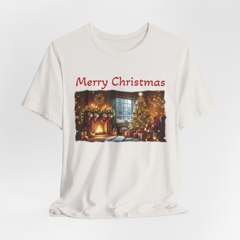 White t-shirt with a ’Merry Christmas’ print featuring a cozy holiday scene of decorated Christmas trees and a fireplace.