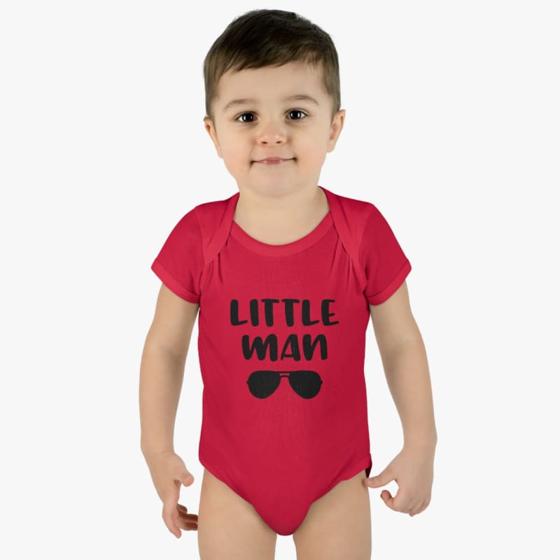 Red onesie with ’LITTLE MAN’ text and sunglasses graphic worn by a young child.