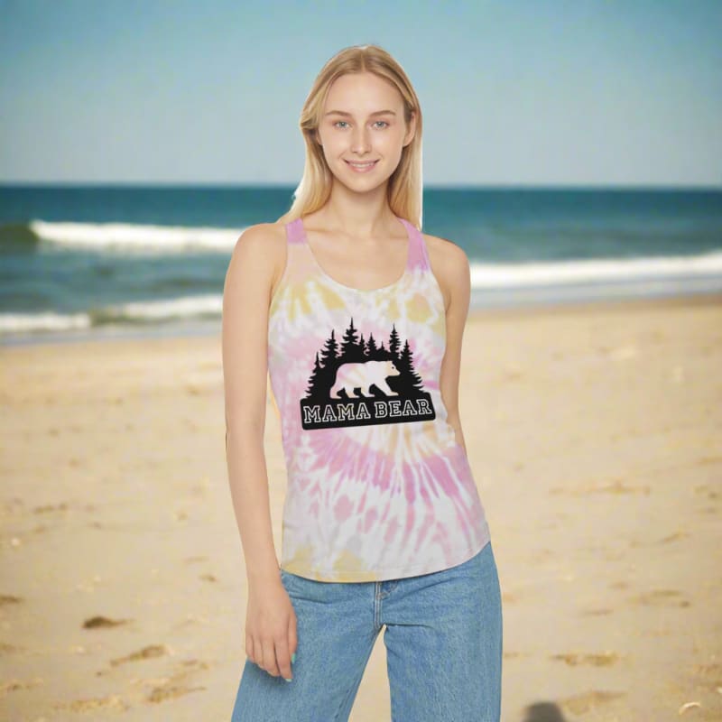 Woman wearing a tie-dye tank top with a ’Mama Bear’ design on a beach.